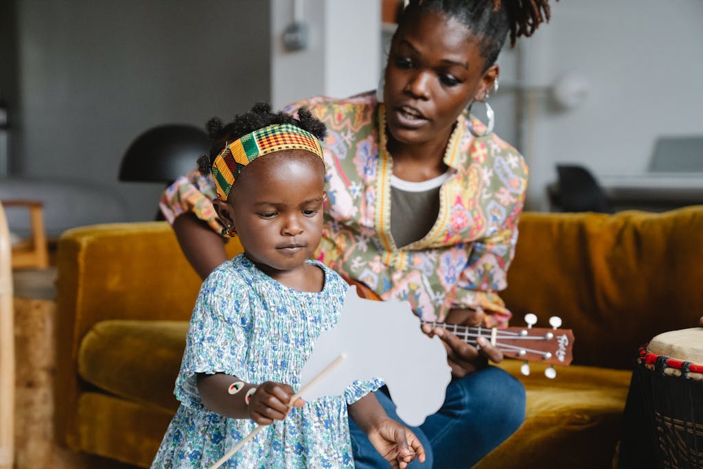 A Mother Playing Ukulele while Singing to Her Daughter