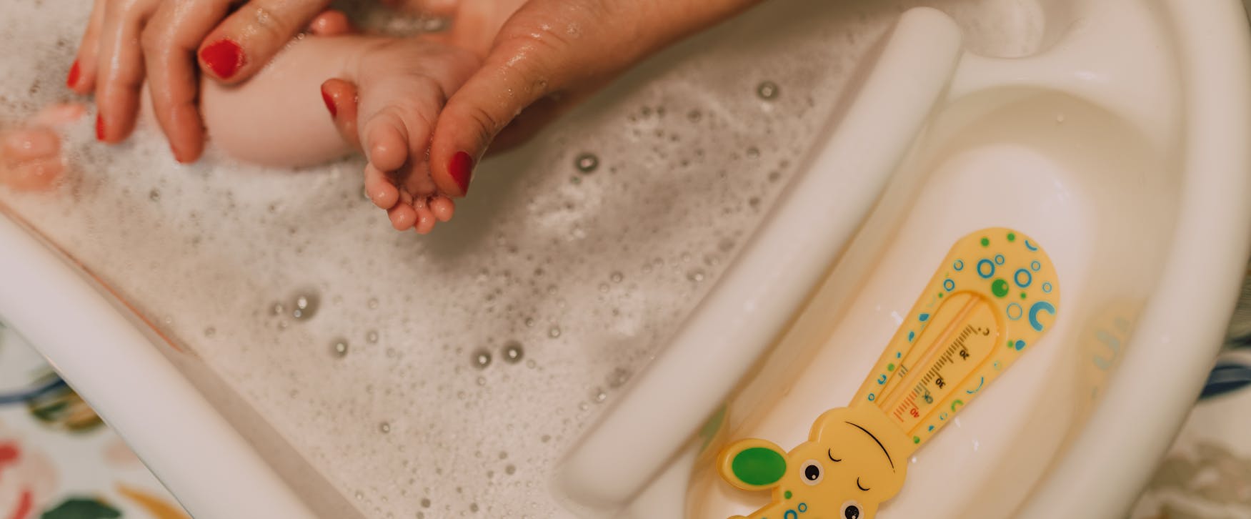 A caring parent gently bathes a baby in a bubbly bathroom scene, showcasing love and hygiene.