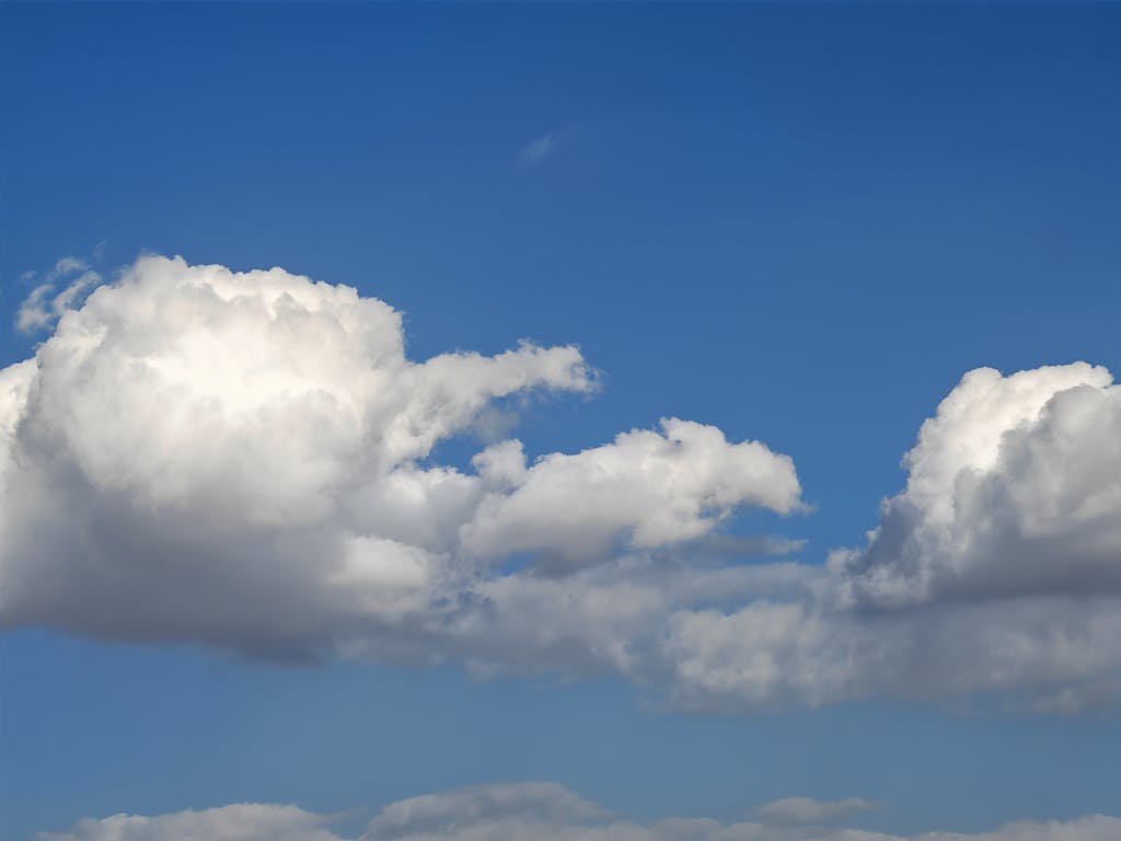 Cumulus clouds against a bright blue sky, creating a serene and peaceful atmosphere.